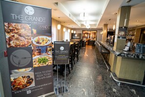 A restaurant interior with a counter, seating area, and a menu stand. - Relaxing condo w/ swimming pool and hot tub <br> Free parking <br> Banff pass incl. (Canmore)