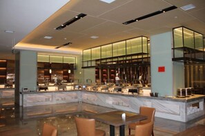 A modern hotel lobby with a central bar area, seating arrangements, and a reflective water feature. - Hezhou Hongrui International Hotel (Linxia)