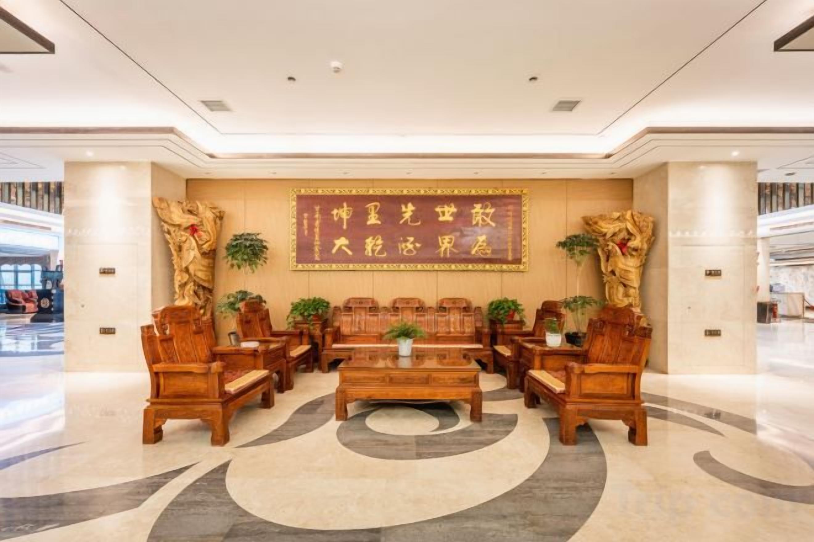 A lobby with a reception desk, seating area, and a large wall with decorative elements.