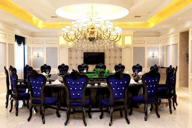 A formal dining room with a chandelier, round table, and six chairs.