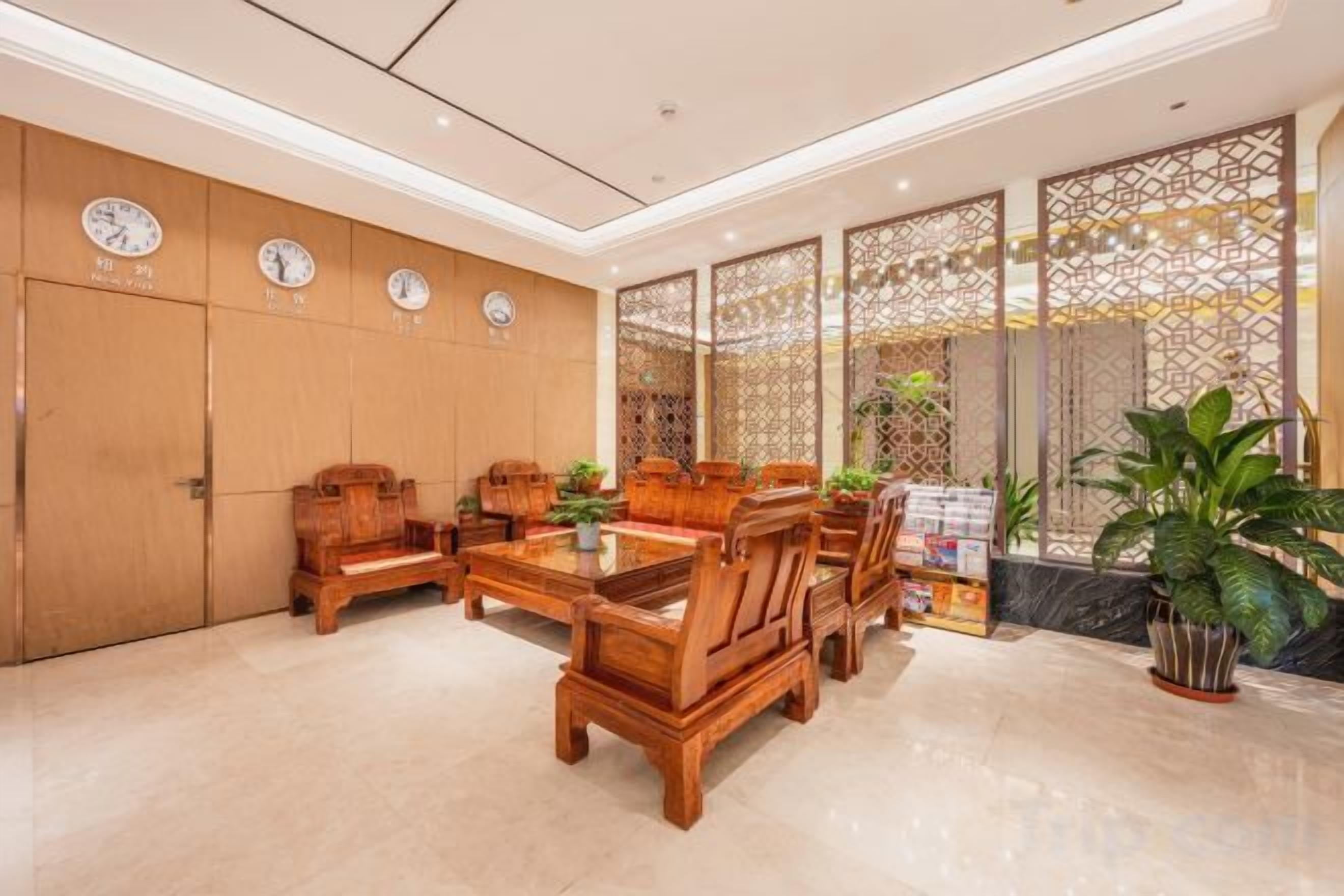 A lobby with wooden furniture, a reception desk, and a decorative screen.