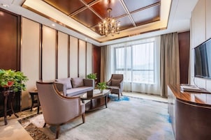 Una sala de estar moderna con un sofá, sillones, una mesa de centro y un televisor.