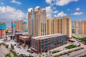 A high-rise building with a modern architectural design, surrounded by other high-rise buildings, and a clear sky.