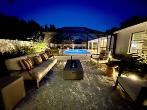 A covered outdoor area with a pool, a sofa, and a coffee table.
