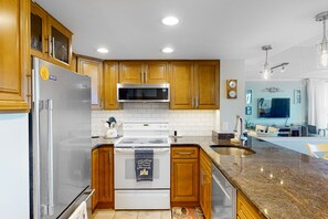 Enjoy cooking in this well-equipped kitchen with a refrigerator, microwave, double oven, and sink.