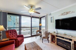 Relax in this stylish living room with a large flat-screen TV, comfortable seating area, and fireplace.