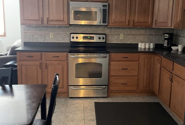 Enjoy cooking in this fully equipped kitchen with a microwave, oven, and ample cabinetry.