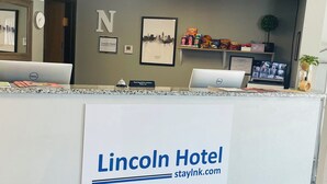 Mostrador de recepción en el Hotel Lincoln, con un letrero que muestra el nombre del hotel y su sitio web.