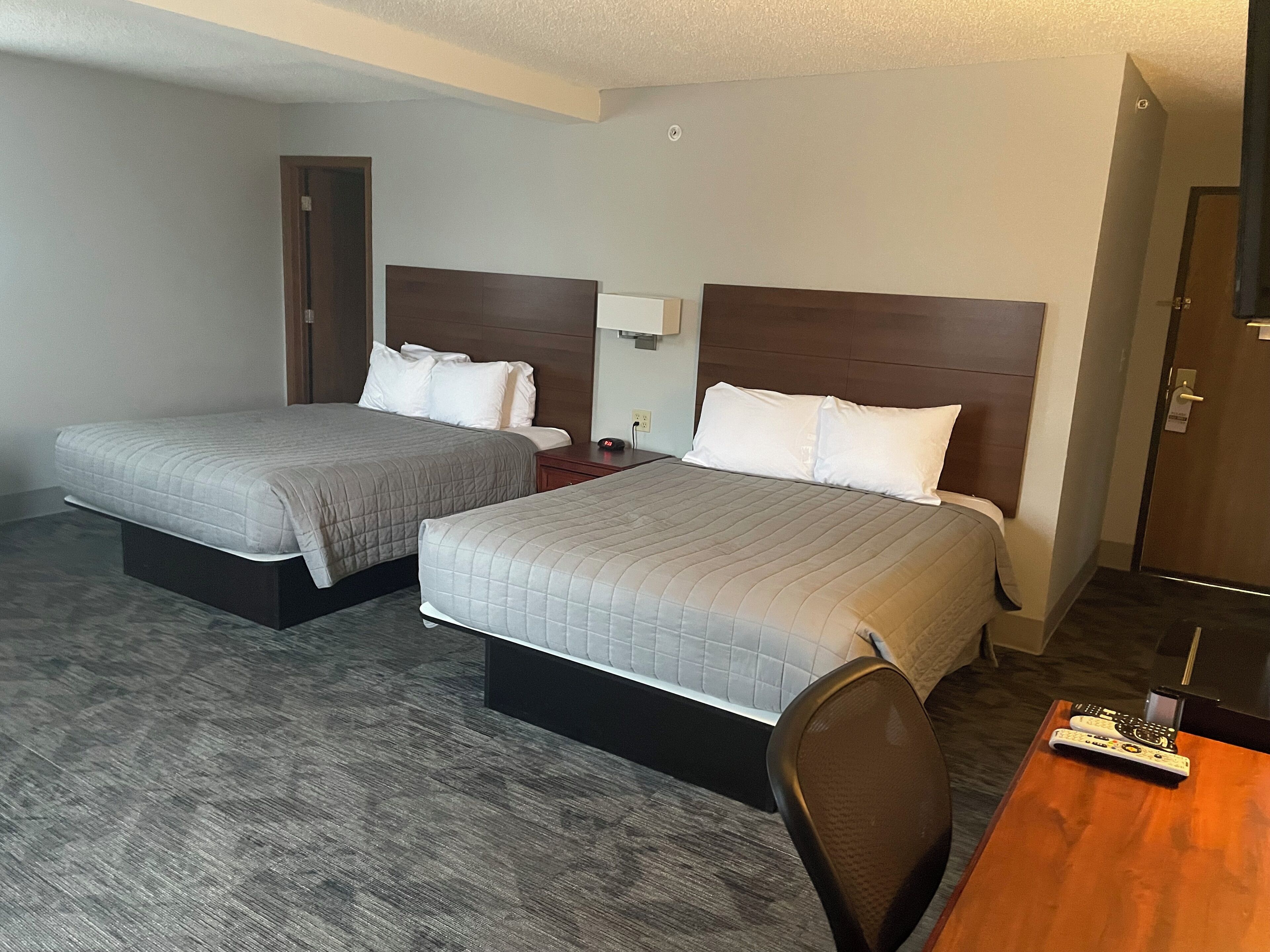Une chambre d’hôtel avec deux lits, une table en bois et une chaise.