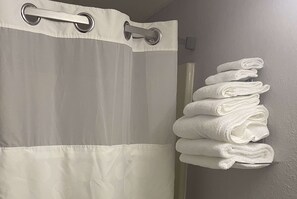 Bathroom features a shower and towel rack.