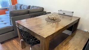 Uma mesa de jantar com acabamento em madeira, acompanhada por um banco e uma cadeira.
