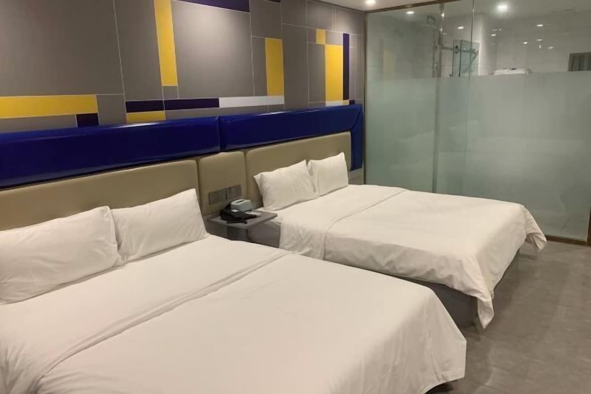 Ein Hotelzimmer mit zwei Betten, einem Nachttisch und einem modernen Wanddesign.