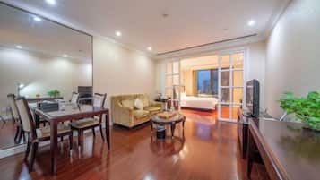 A modern living room with a dining table, sofa, and TV.
