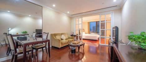 A modern living room with a dining table, sofa, and TV.