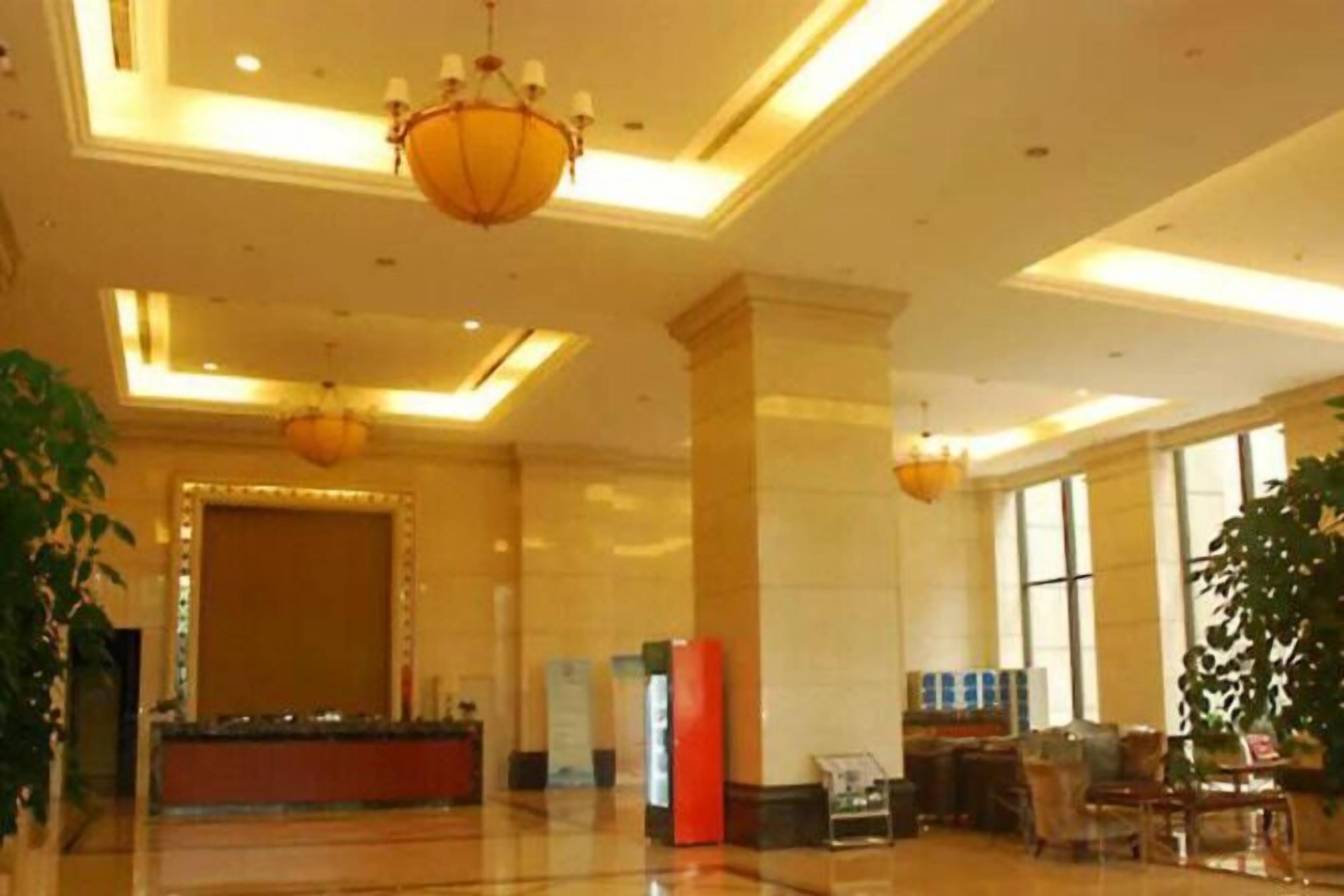 A spacious lobby with a reception desk, seating area, and large windows.