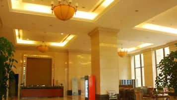 A spacious lobby with a reception desk, seating area, and large windows.