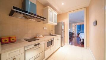 A modern kitchen with a built-in oven, a stainless steel refrigerator, and a microwave.