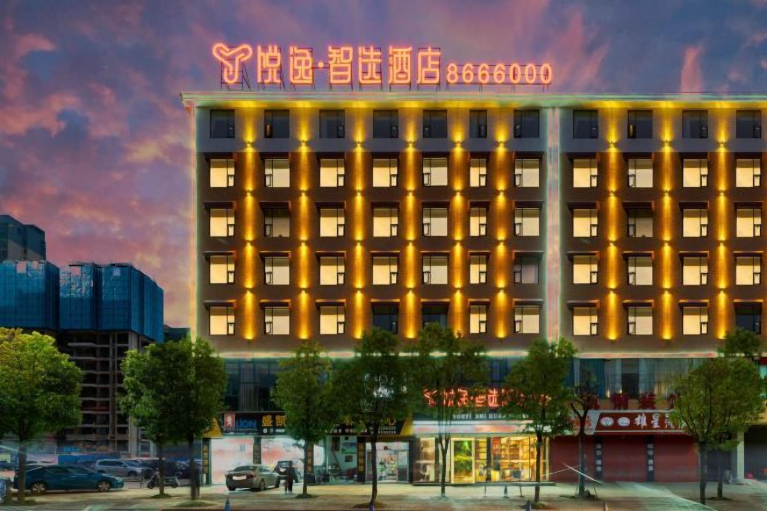 A multi-story hotel with a row of uniformly lit windows and a prominent entrance.