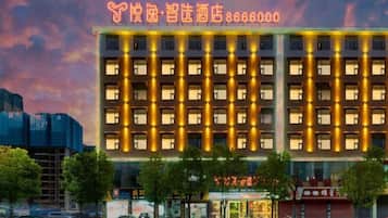 A multi-story hotel with a row of uniformly lit windows and a prominent entrance.