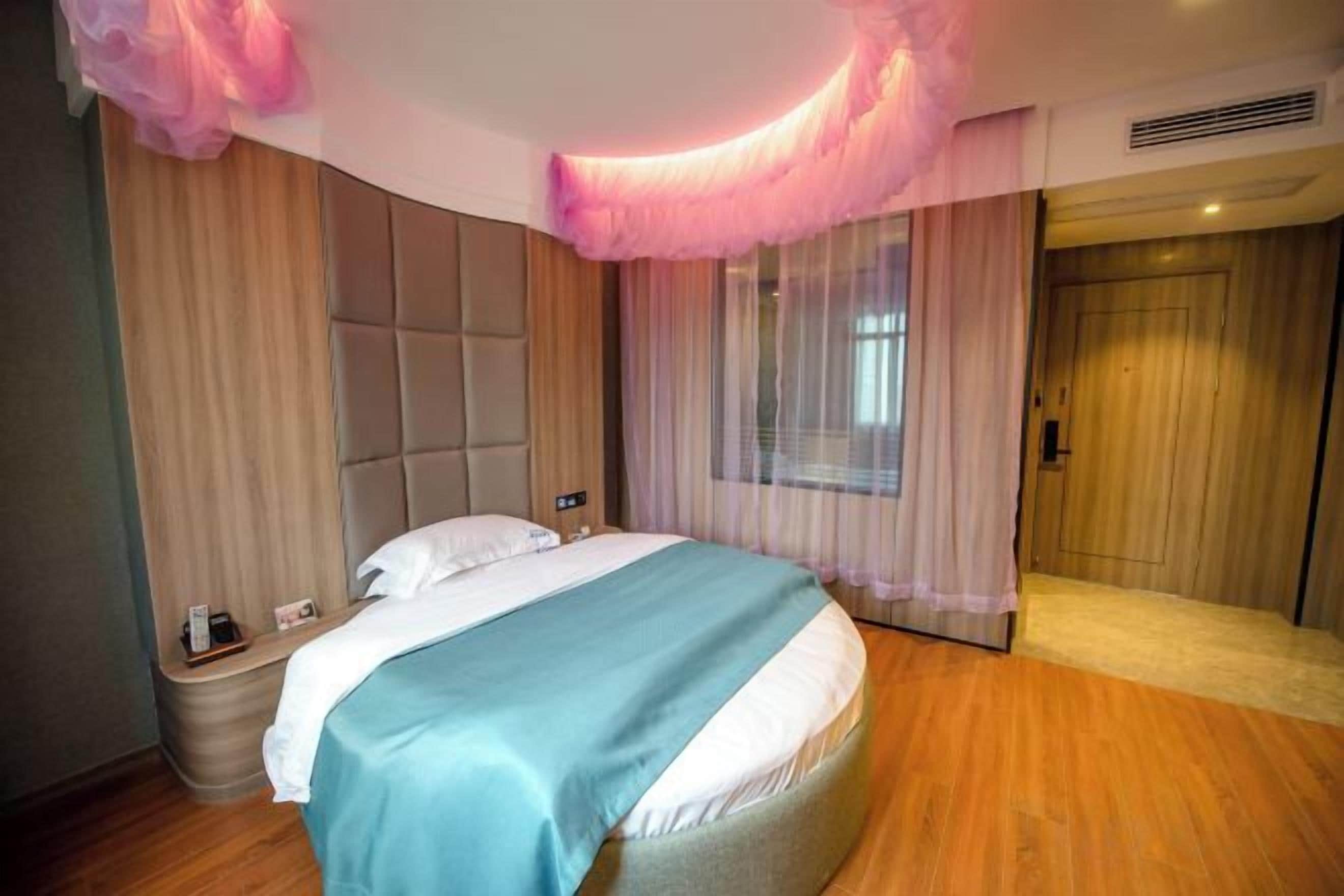 A bedroom with a large bed, a bedside table, and a wardrobe.