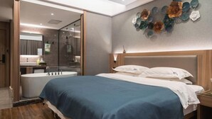 A modern bedroom with a large bed, a bathroom with a bathtub, and a decorative wall art piece. - Meng Zhi Dao Hotel (Loudi)