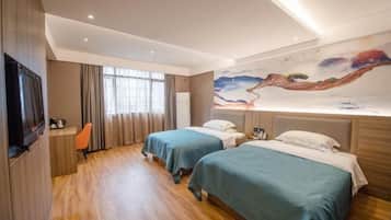 Habitación de hotel con dos camas, un escritorio, un televisor y un mural en la pared.