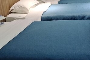 A hotel room with a bed covered in blue bedding, a white pillow, and a white blanket. - Meng Zhi Dao Hotel (Loudi)