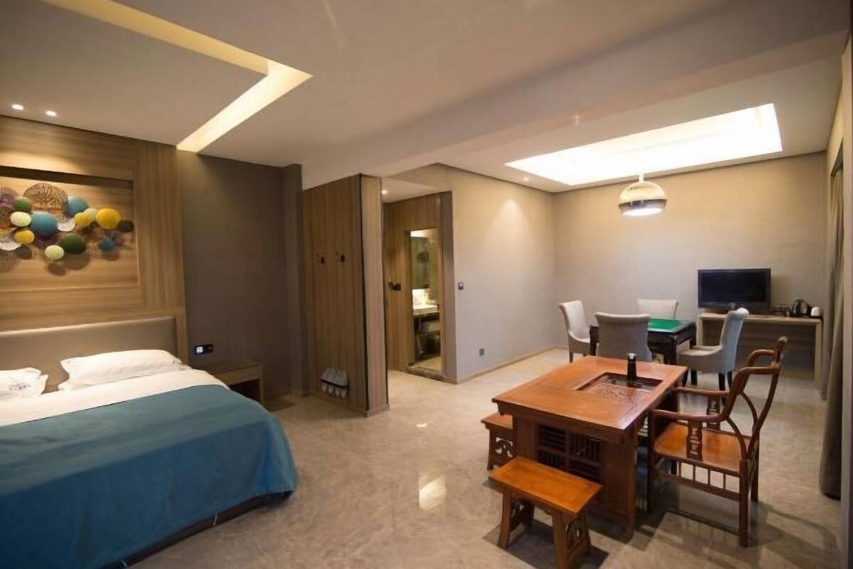 Une chambre d’hôtel moderne équipée d’un lit, d’une table à manger en bois et d’un téléviseur.