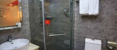 A bathroom with a glass-enclosed shower, a white sink, and a toilet.