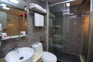 Une salle de bain moderne avec une douche à parois de verre, un lavabo blanc et des toilettes.