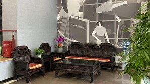 A lobby with traditional wooden furniture, a glass coffee table, and a 'THANK HOTEL' sign on the wall. - Shankee Chain Hotel (Shenzhen Longhua Qinghu Subway Station) (Shenzhen)