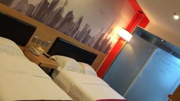 Quarto de hotel com duas camas, uma mesa de cabeceira, um abajur e uma parede com um mural da paisagem urbana.