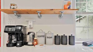 A kitchen with a coffee maker, sugar container, and storage jars. - Fox Cottage *Pet Friendly* (Catonsville)