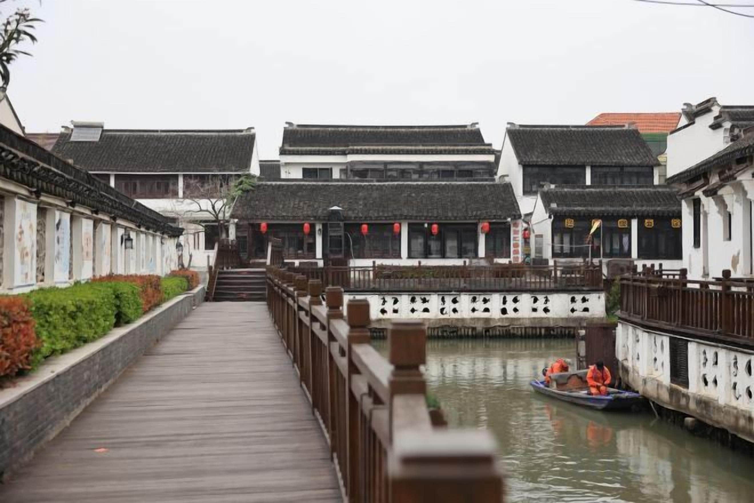 A traditional wooden bridge over a canal with buildings on either side.