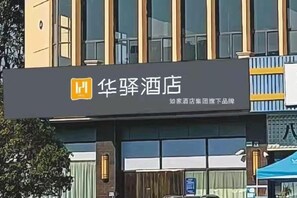 A hotel sign with the name '华驿酒店' and a logo.