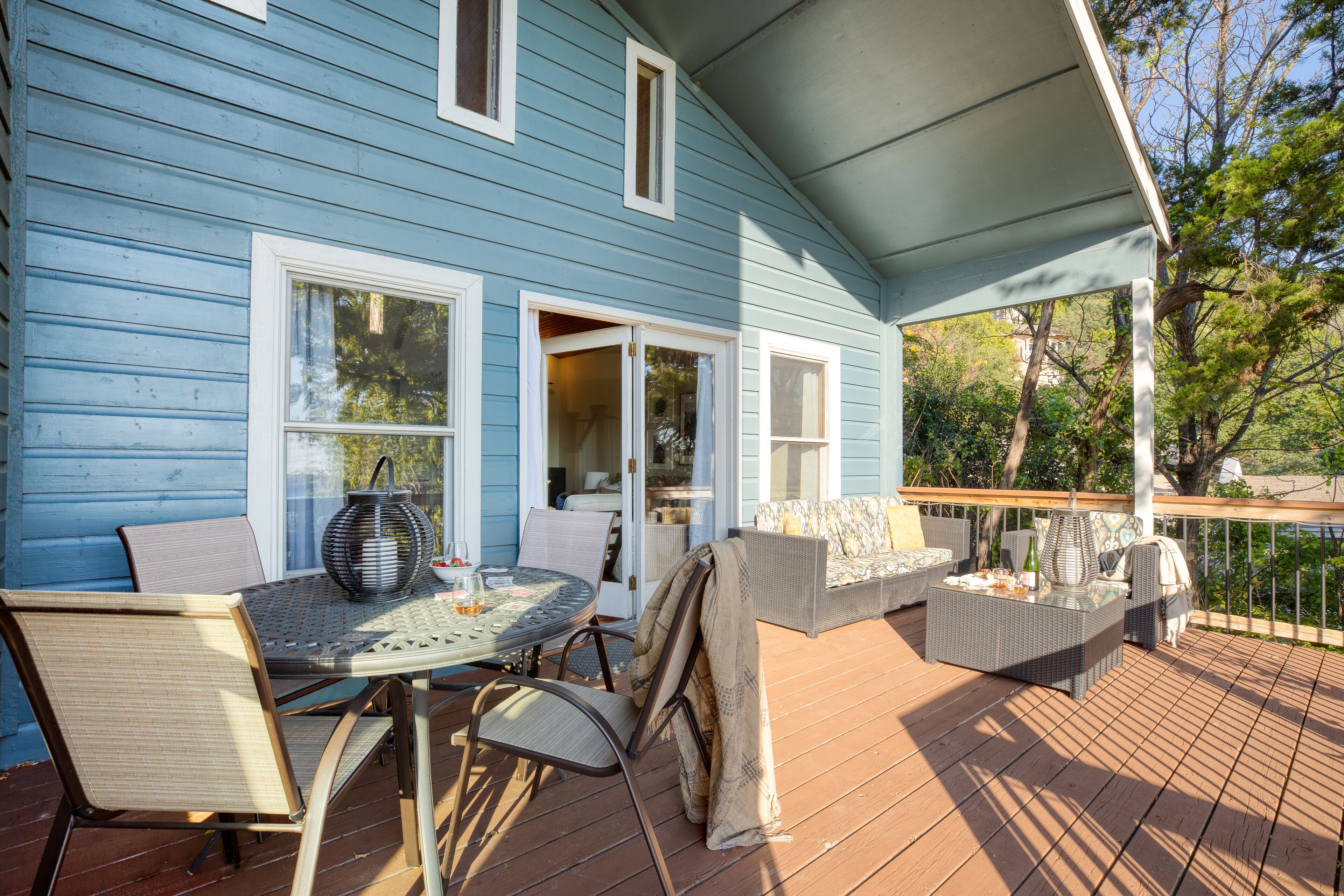 Une terrasse couverte, aménagée avec du mobilier d’extérieur, notamment une table, des chaises et un canapé.