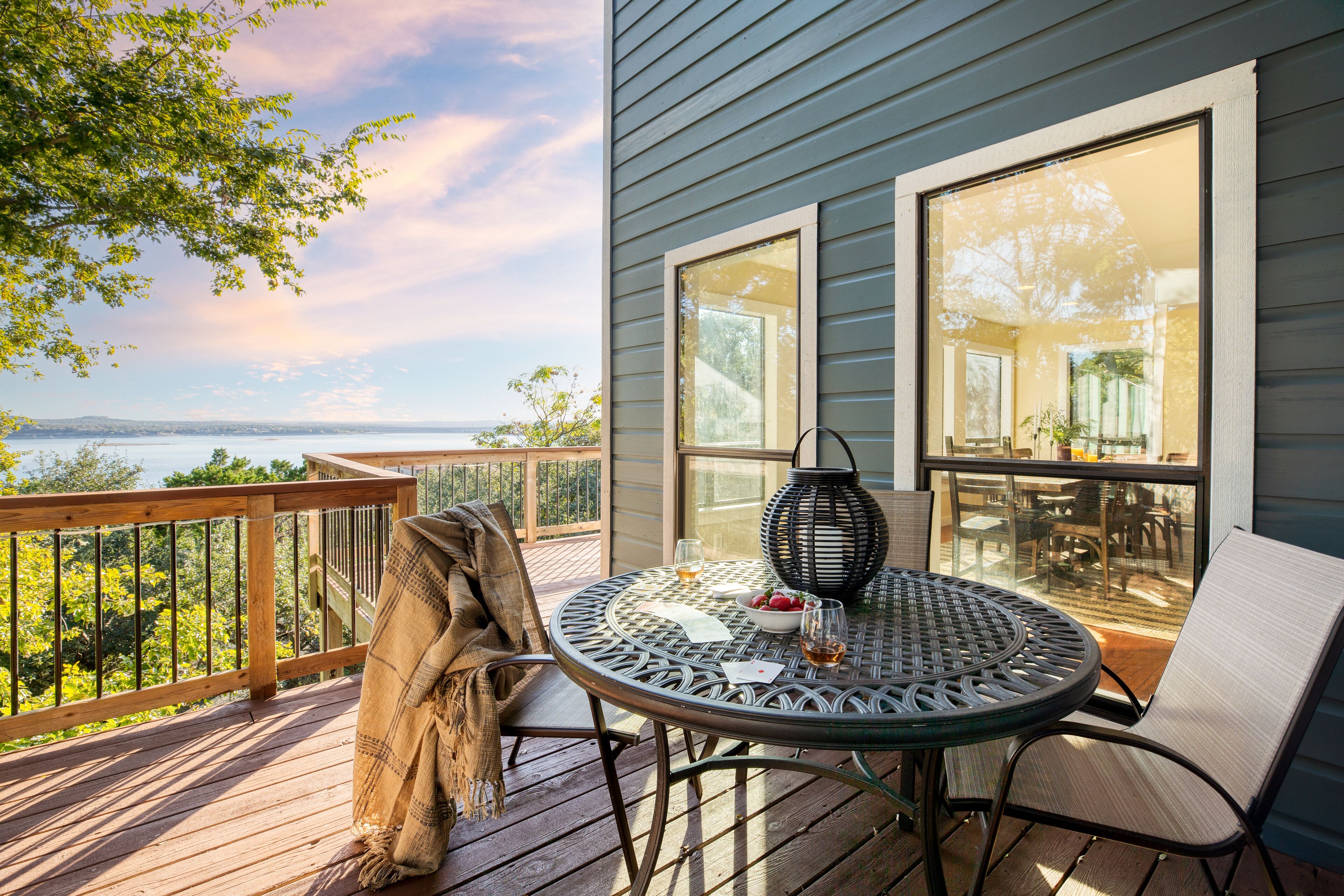 Une terrasse avec une table ronde, des chaises et une couverture.
