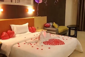 A hotel room with a bed, pillows, a nightstand, a chair, and a small table. - 7 Days Premium (Shenzhen Bao'an Bus Station Haiya Mega Mall) (Shenzhen)