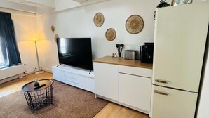 A modern kitchen with white cabinets, a built-in oven, and a refrigerator.