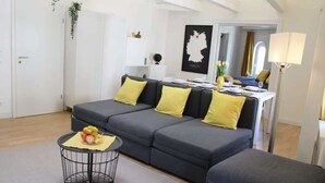 A modern living room with a grey sectional sofa, a round black coffee table, and a small side table.
