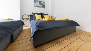 Ein Zimmer mit einem Bett, einem Nachttisch und einer Wandlampe.