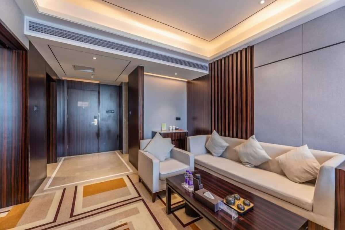 Een moderne hotellobby met een bank, stoelen, een salontafel en een receptiebalie.