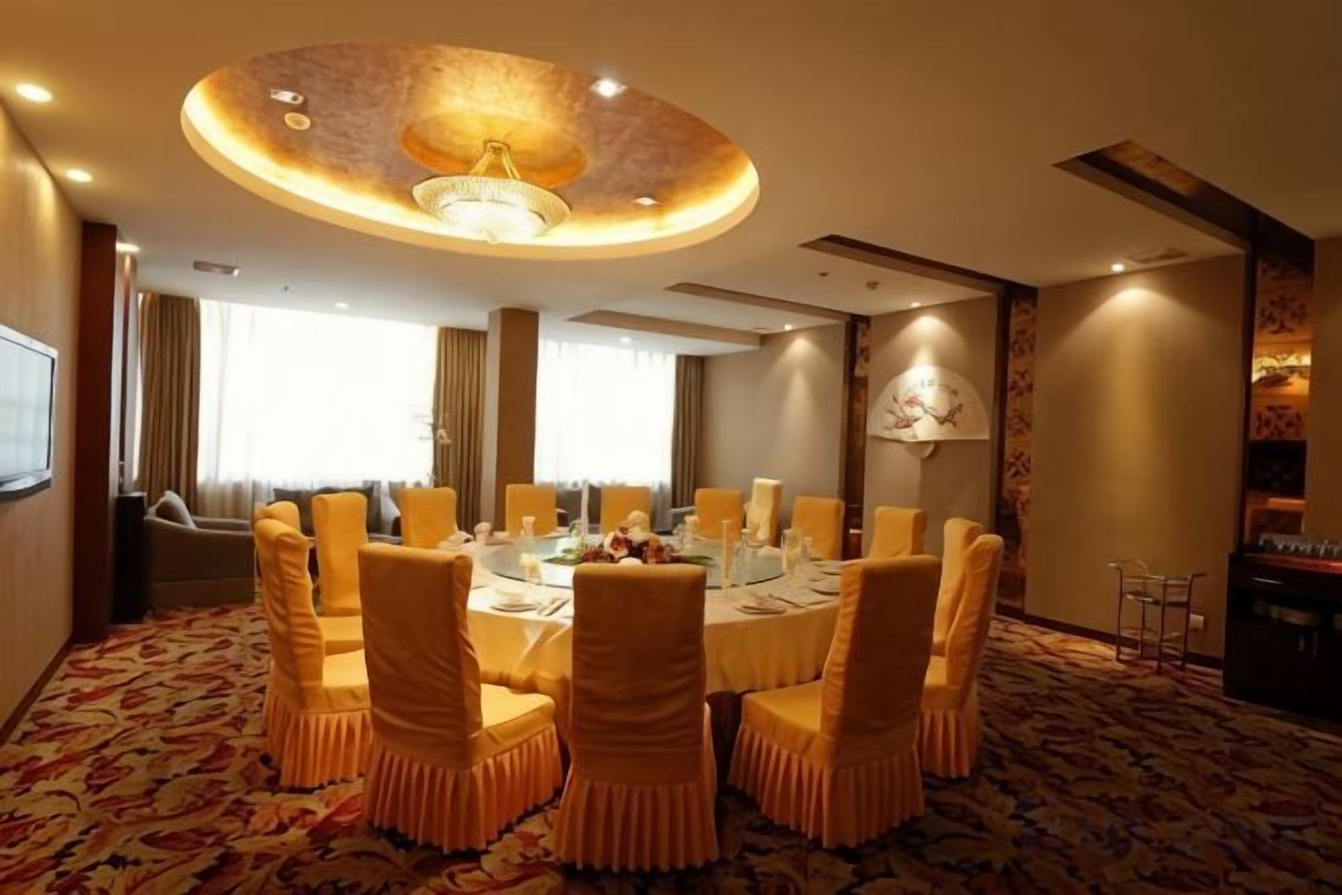 A conference room with a round table, chairs, and a chandelier.