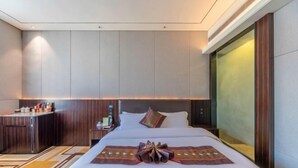 A hotel room with a large bed, a small desk, a minibar, and a large window. - Huafeng Huatian Hotel (Yongzhou)