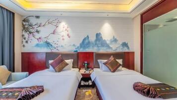 A hotel room with two beds, a nightstand, and a wall mural.