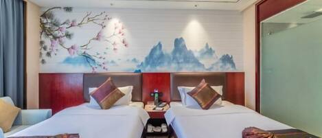 Una habitación de hotel con dos camas, una mesita de noche y un mural en la pared.