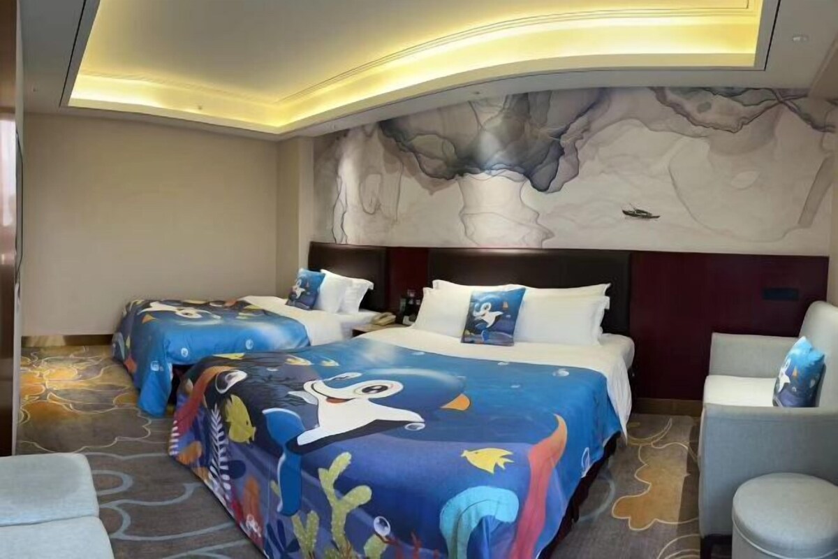 A hotel room with two beds, a large mural on the wall, and a modern ceiling design.
