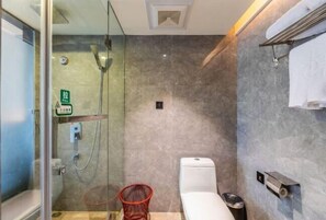 Ein modernes Badezimmer mit Duschkabine aus Glas, Toilette und einem roten Stuhl.