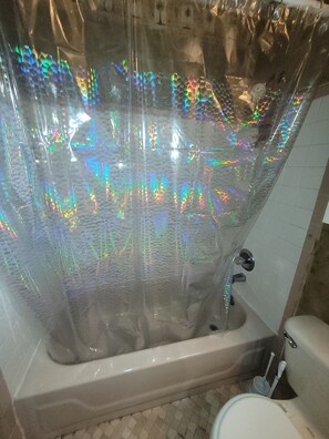 Een bad/douchecombinatie, handdoeken, toiletpapier