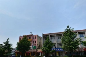 A street view with buildings, trees, and a clear sky. - Laike Yangming Hotel (Chizhou)